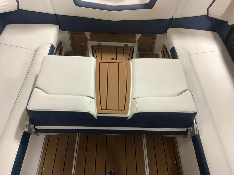 Slide: The Image of 2025 Nautique G25 boat interior with white and navy seating, wooden flooring. - 21
