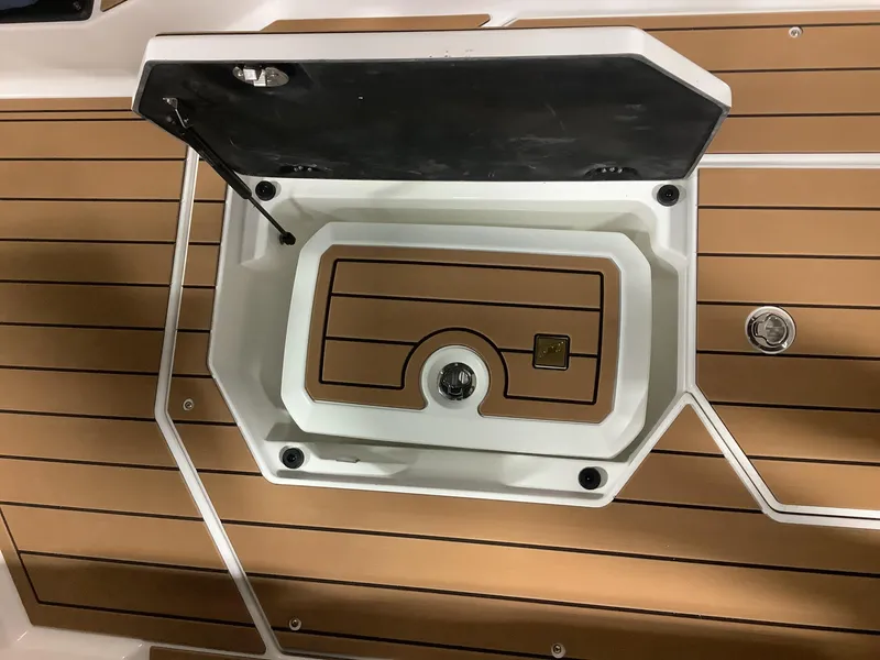 Slide: The Image of 2025 Nautique G25 boat storage compartment with teak flooring. - 27