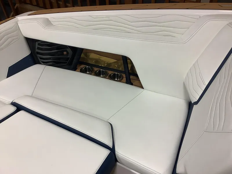 Slide: The Image of 2025 Nautique G25 boat interior with white leather seating and speaker system. - 8