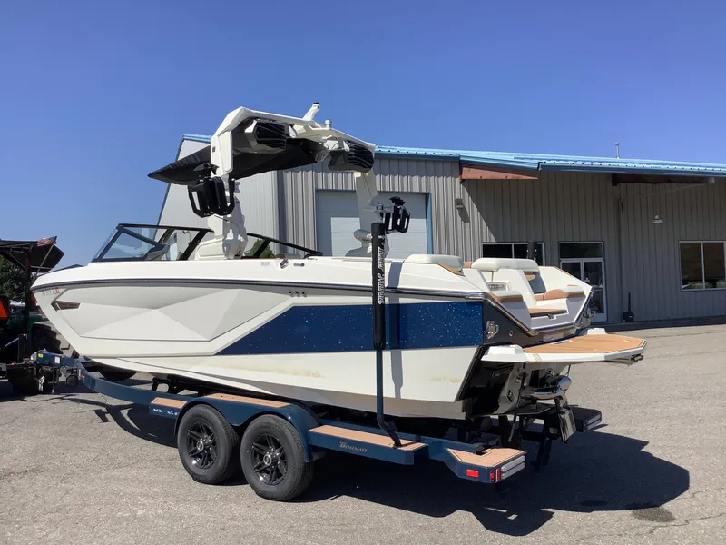 Slide: The Image of 2024 Nautique Super Air G23 boat on trailer, parked outside a building. - 13