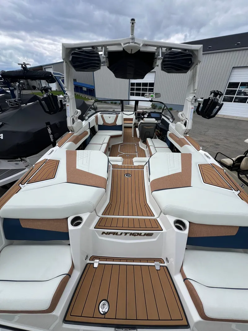 Slide: The Image of 2024 Nautique Super Air G23 boat interior with luxurious seating and teak flooring. - 16