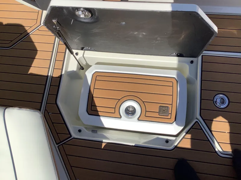 Slide: The Image of 2024 Nautique Super Air G23 storage compartment with teak-style flooring. - 27