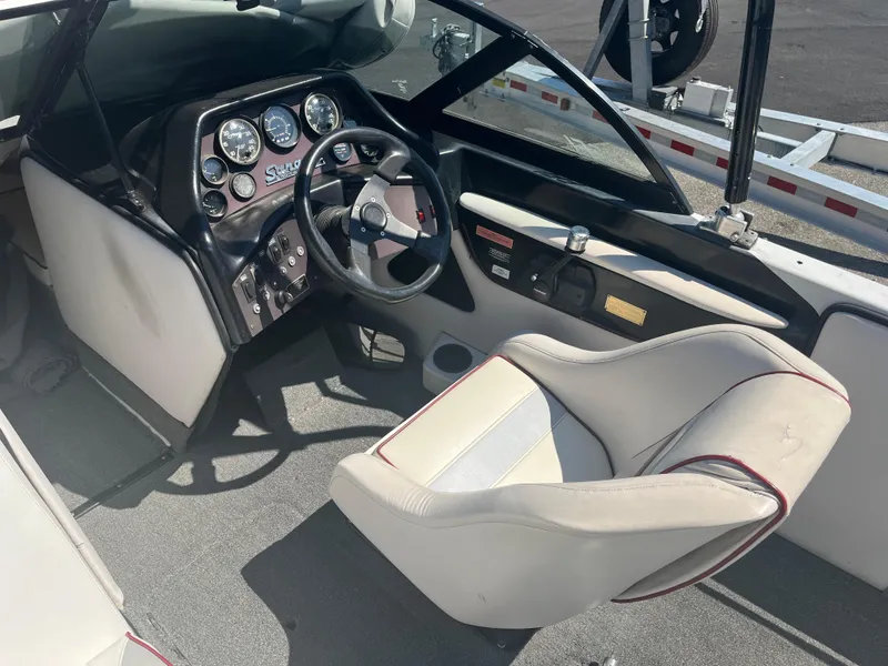 Slide: The Image of Interior of a 1999 Sanger Ski Sanger boat, featuring steering wheel and dashboard controls. - 10