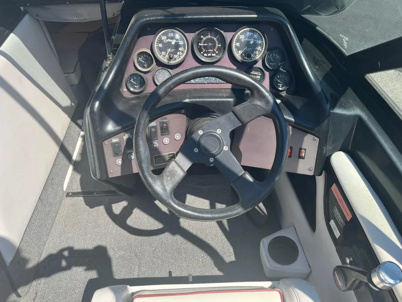 Slide: The Image of 1999 Sanger Ski Sanger boat dashboard with steering wheel and gauges. - 11