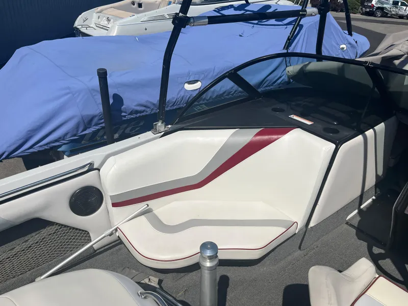 Slide: The Image of 1999 Sanger Ski Sanger boat interior with white and red seating, covered boats in background. - 12