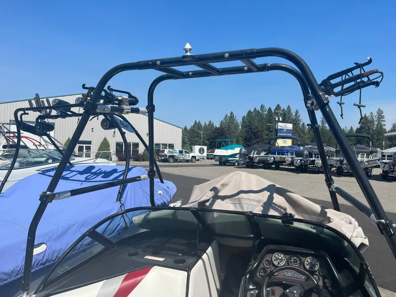 Slide: The Image of 1999 Sanger Ski Sanger boat with wakeboard tower in a marina setting. - 14