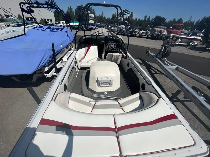 Slide: The Image of 1999 Sanger Ski Sanger boat interior with white and red seating, parked outdoors. - 6