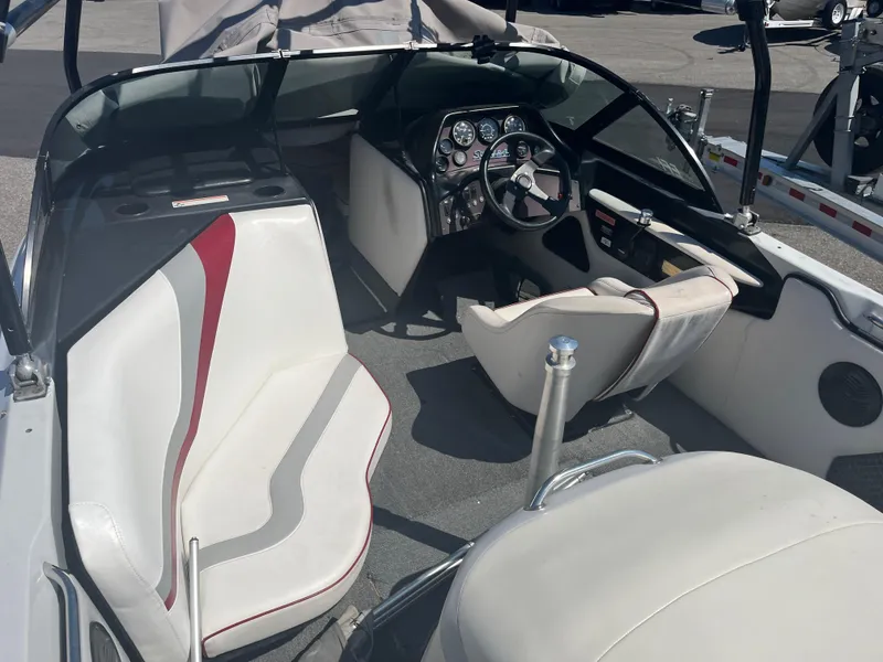 Slide: The Image of 1999 Sanger Ski Sanger boat interior with white and red seating, dashboard, and steering wheel. - 9