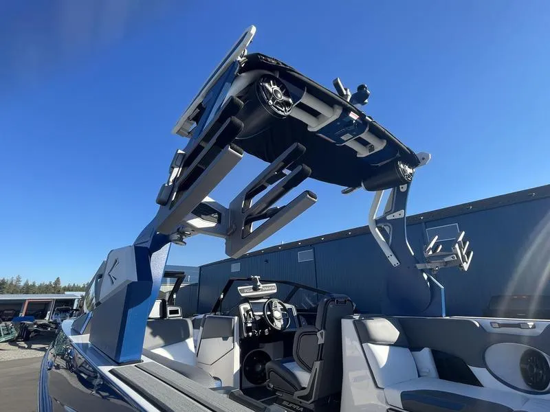 Slide: The Image of 2023 Supra SA 450 boat with advanced wakeboard tower and speakers under clear blue sky. - 10