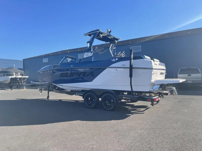Slide: The Image of 2023 Supra SA 450 boat on trailer in sunny outdoor setting. - 6