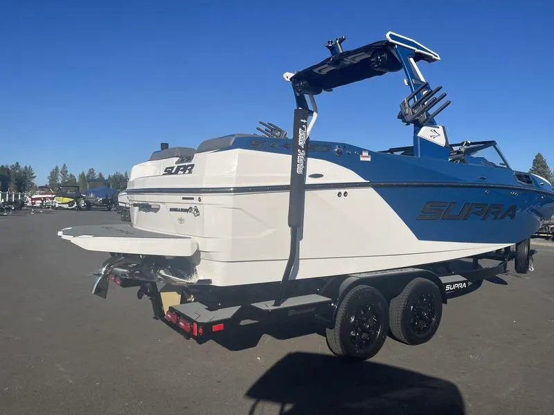Slide: The Image of 2023 Supra SA 450 boat on trailer, blue and white design, sunny day. - 7