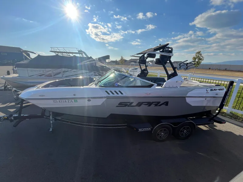 Slide: The Image of 2017 Supra SA 450 boat on trailer under sunny sky. - 10