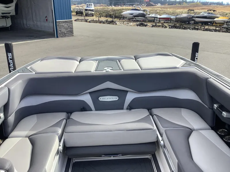 Slide: The Image of 2017 Supra SA 450 boat interior with gray seating, docked near other boats. - 36