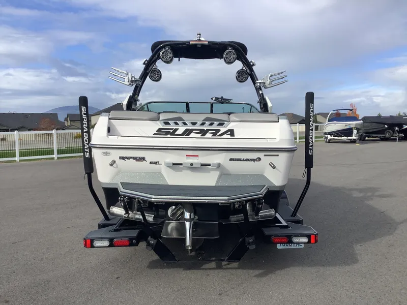 Slide: The Image of 2017 Supra SA 450 boat, rear view, parked on pavement under cloudy sky. - 7