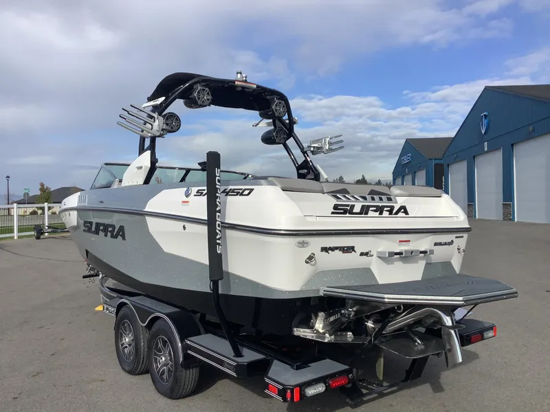 Slide: The Image of 2017 Supra SA 450 boat on trailer near blue building under cloudy sky. - 8