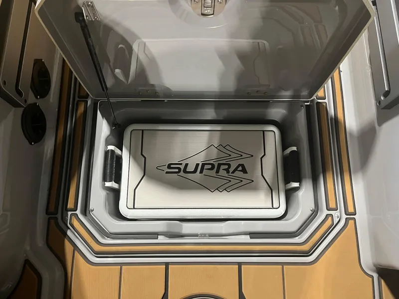 Slide: The Image of 2023 Supra SE 550 storage compartment with branded cooler. - 25