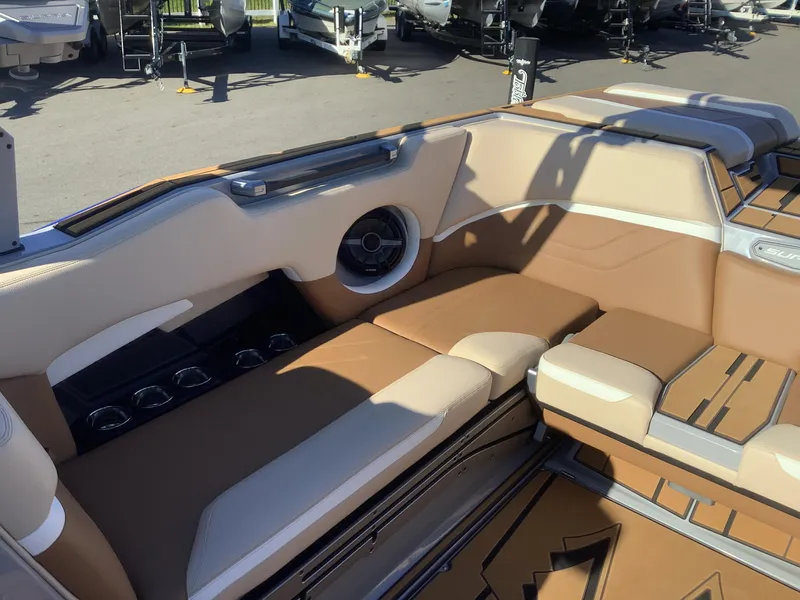 Slide: The Image of 2023 Supra SE 550 boat interior with tan seating and cup holders. - 31