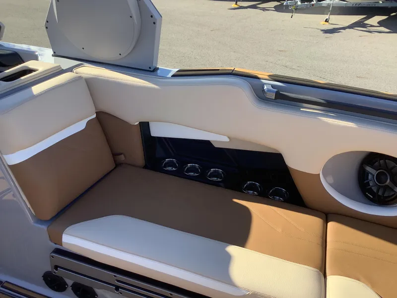 Slide: The Image of 2023 Supra SE 550 boat interior with tan and white seating, speaker, and cup holders. - 32