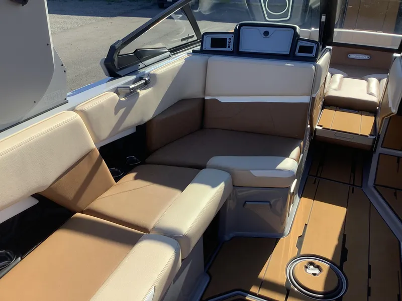 Slide: The Image of 2023 Supra SE 550 boat interior with tan and cream seating, modern dashboard. - 33