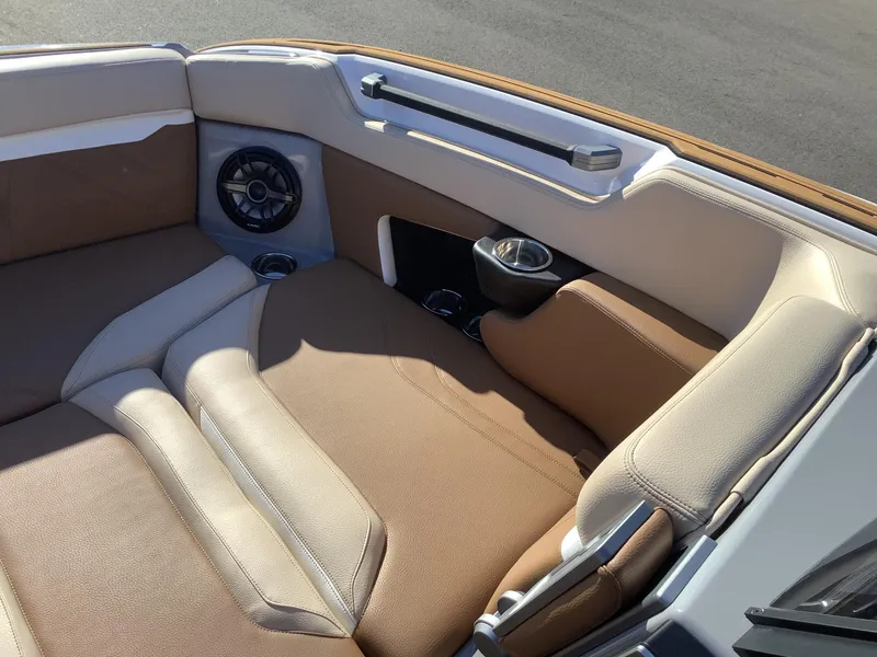 Slide: The Image of 2023 Supra SE 550 boat interior with beige and brown seating, speaker, and cup holder. - 41