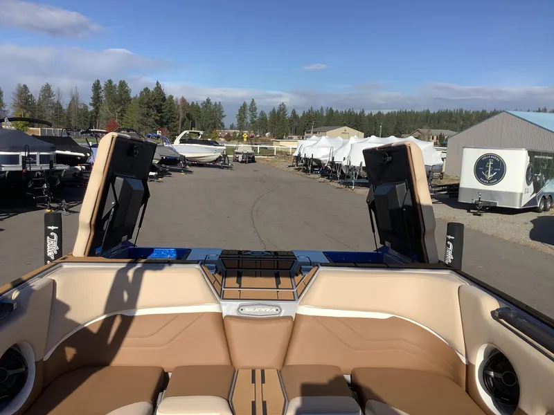 Slide: The Image of 2023 Supra SE 550 boat interior with open compartments, parked outdoors. - 43