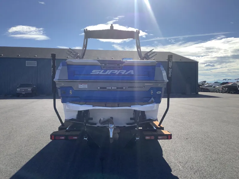Slide: The Image of 2023 Supra SE 550 boat on trailer in sunny outdoor setting. - 8