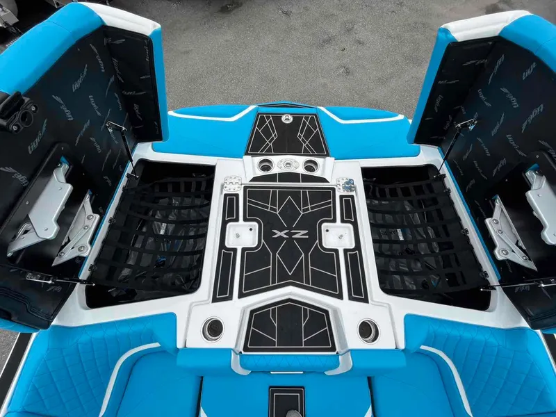 Slide: The Image of 2023 Tigé 25ZX boat interior with blue and black seating and storage compartments. - 11