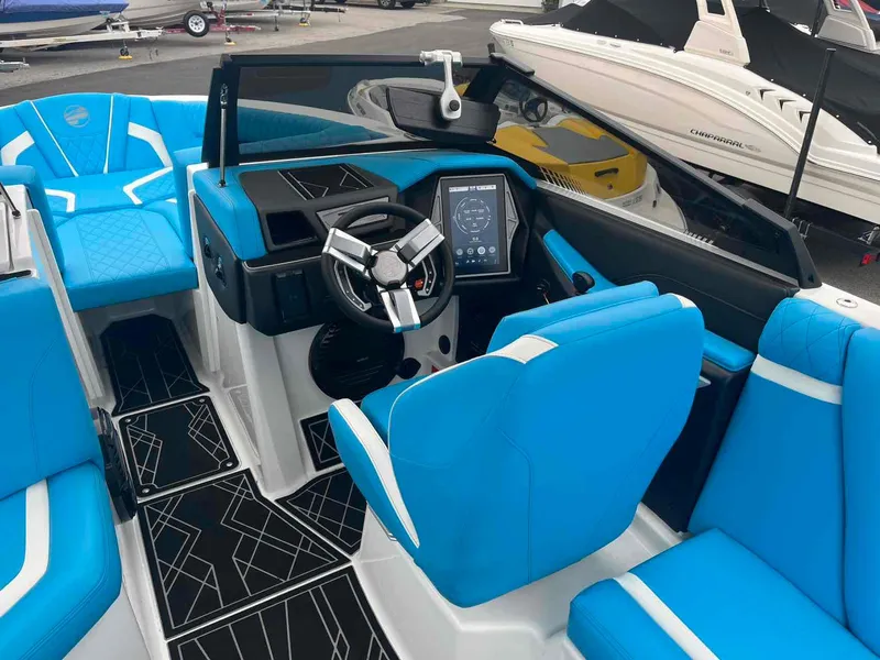 Slide: The Image of 2023 Tigé 25ZX boat interior with blue seating and modern dashboard. - 17