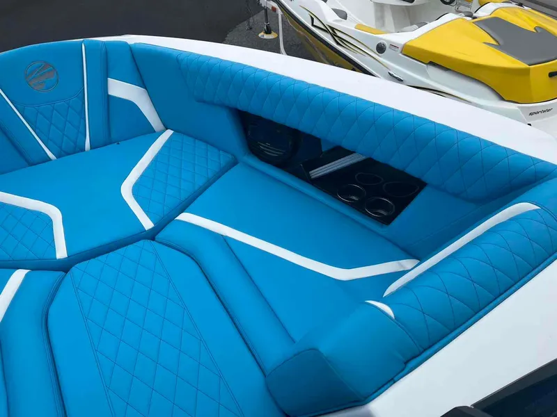 Slide: The Image of 2023 Tigé 25ZX boat interior with blue and white upholstery, cup holders visible. - 8