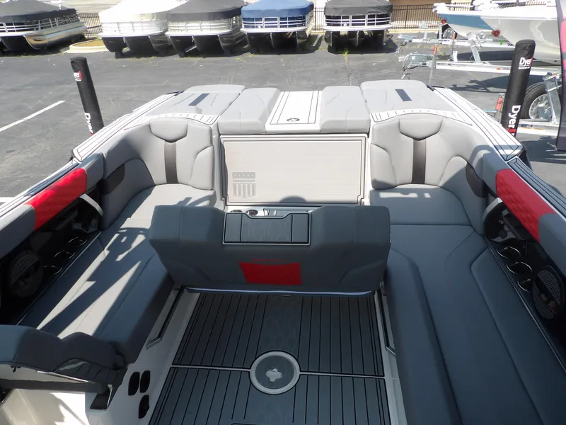 Slide: The Image of 2024 MasterCraft XT25 boat interior with gray seating and red accents. - 11