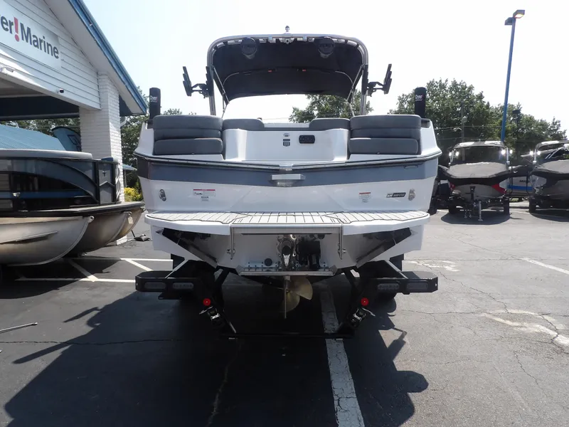 Slide: The Image of 2024 MasterCraft XT25 boat rear view in a dealership parking lot. - 4
