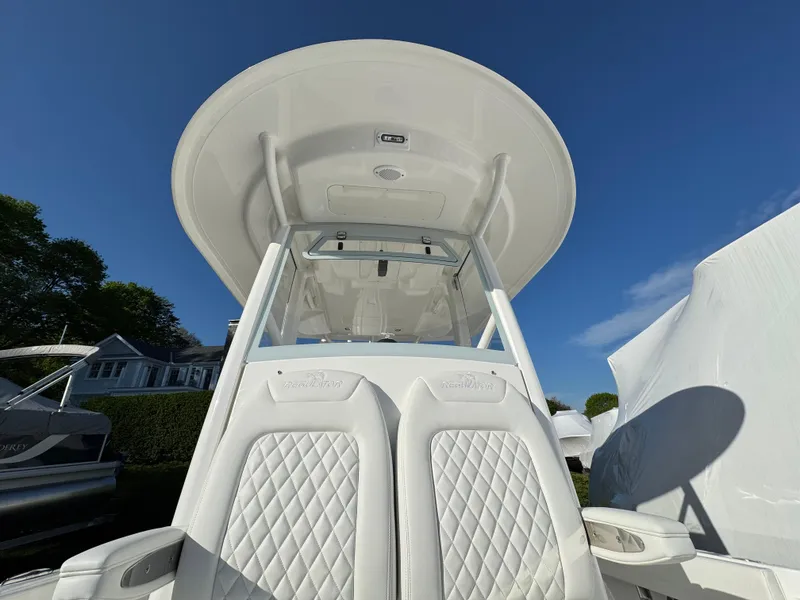 Slide: The Image of 2025 Regulator 26XO boat with white seating and T-top under clear blue sky. - 20