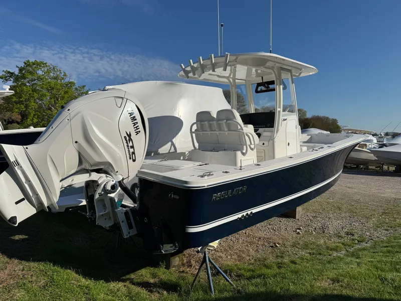 Slide: The Image of 2025 Regulator 26XO boat with Yamaha engine, parked on grass under clear blue sky. - 3