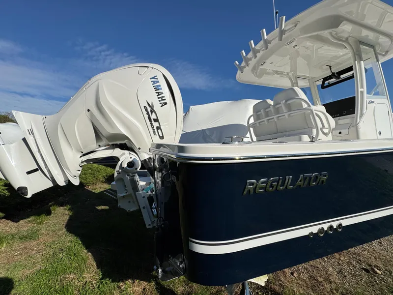 Slide: The Image of 2025 Regulator 26XO boat with Yamaha engine, parked on grass under clear blue sky. - 4