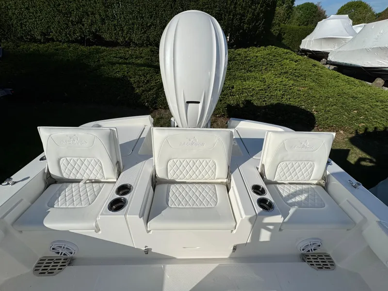Slide: The Image of 2025 Regulator 26XO boat with white cushioned seating and cup holders. - 7