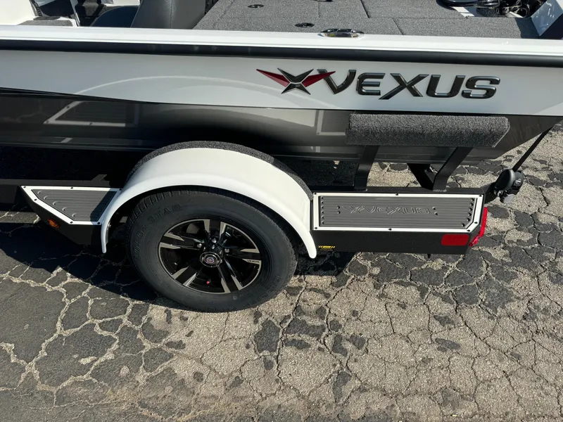 Slide: The Image of 2025 Vexus AVX 1880 boat trailer with black wheel on cracked pavement. - 5