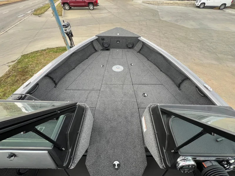 Slide: The Image of 2025 Lund 2075 IMPACT XS boat interior with spacious deck and windshield view. - 13