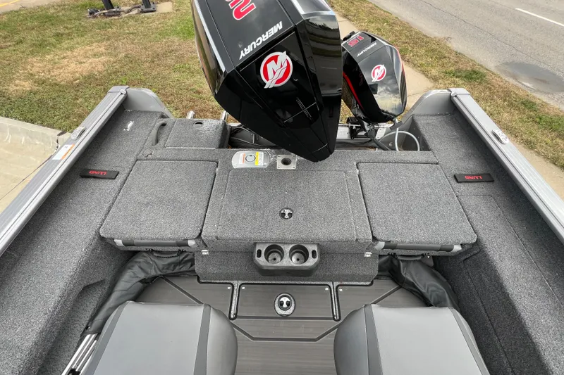 Slide: The Image of 2025 Lund 2075 IMPACT XS boat interior with Mercury engine, gray seating, and storage compartments. - 16