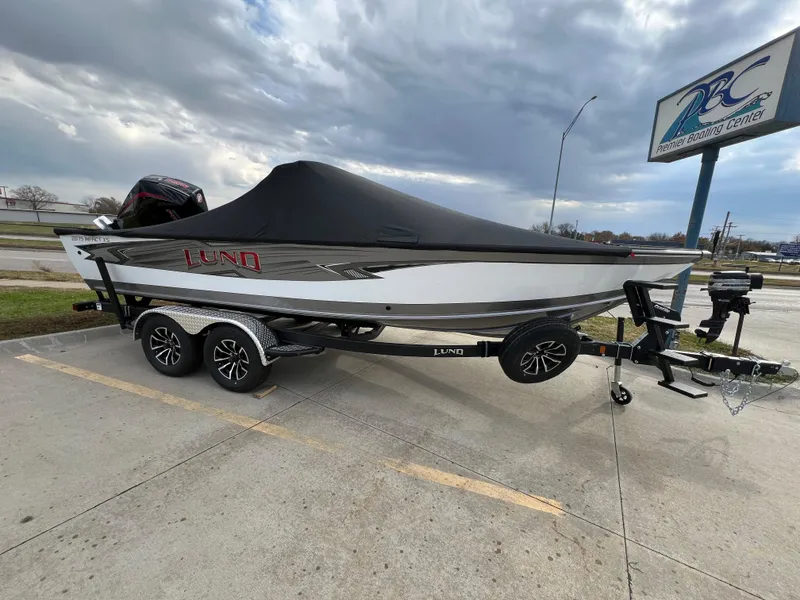 Slide: The Image of 2025 Lund 2075 IMPACT XS boat on trailer, parked outdoors. - 2