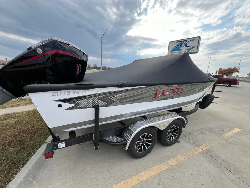 Slide: The Image of 2025 Lund 2075 IMPACT XS boat on trailer, covered, parked outdoors. - 3