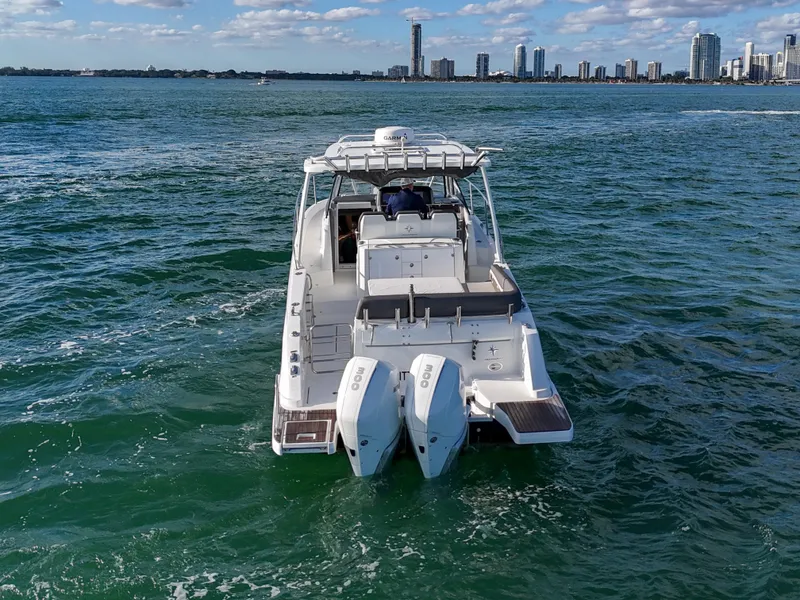 Slide: The Image of 2019 Jeanneau 34 boat cruising on open water with city skyline in background. - 11
