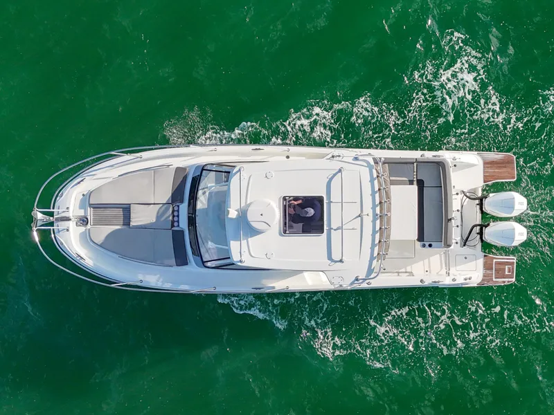 Slide: The Image of Aerial view of 2019 Jeanneau 34 boat cruising on green water. - 12