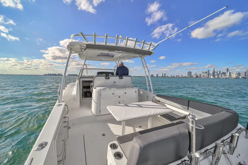 Slide: The Image of 2019 Jeanneau 34 boat cruising on open water with city skyline in background. - 19
