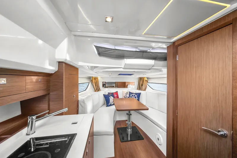 Slide: The Image of 2019 Jeanneau 34 yacht interior with modern kitchen and cozy seating area. - 28
