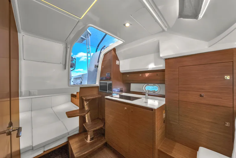 Slide: The Image of Modern interior of 2019 Jeanneau 34 yacht with sleek wood finishes and white seating. - 32