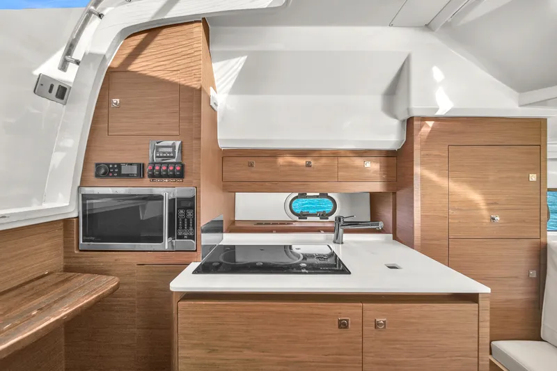 Slide: The Image of Modern kitchen interior of 2019 Jeanneau 34 yacht with wood cabinetry and appliances. - 33
