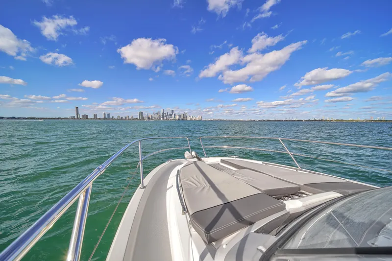 Slide: The Image of 2019 Jeanneau 34 boat cruising with city skyline in the background. - 38