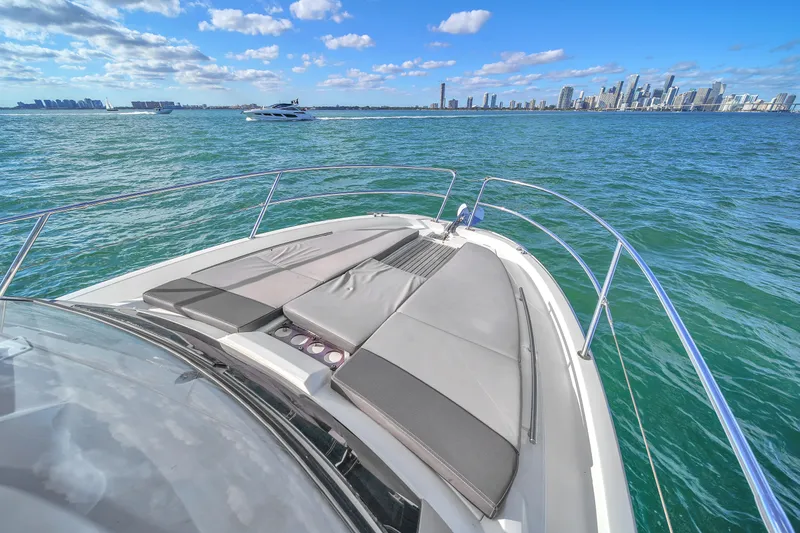 Slide: The Image of 2019 Jeanneau 34 boat cruising on blue water with city skyline in background. - 39