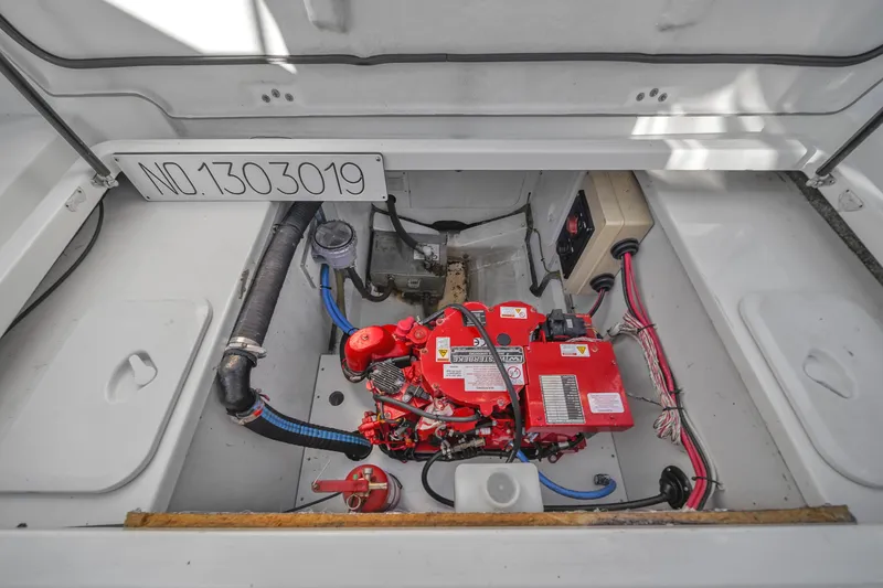 Slide: The Image of Engine compartment of 2019 Jeanneau 34 boat with red engine and wiring. - 42
