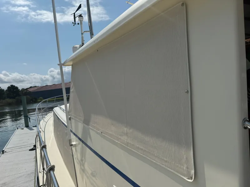 Slide: The Image of 2003 Dettling 51 Express Cruiser docked, side view with sunshade, clear sky background. - 13